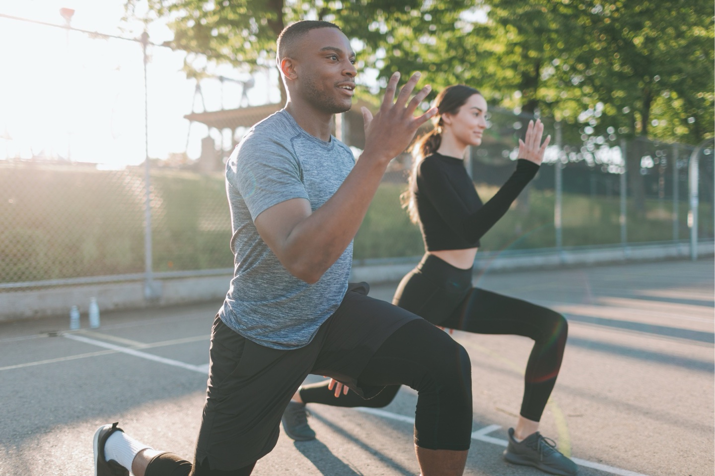 Two people doing lunges outdoors