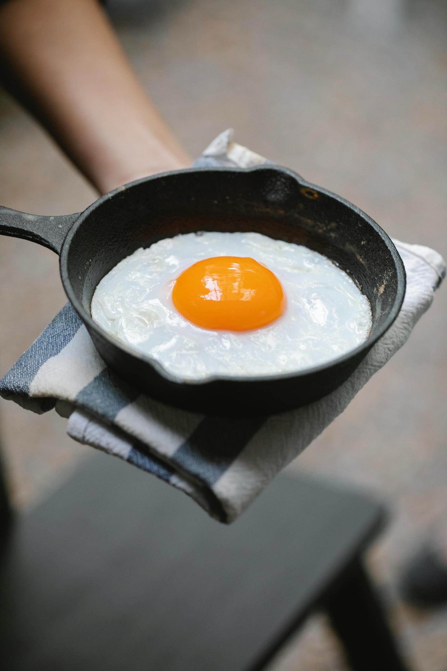 Sunny-side-up egg cooking in a cast iron skillet